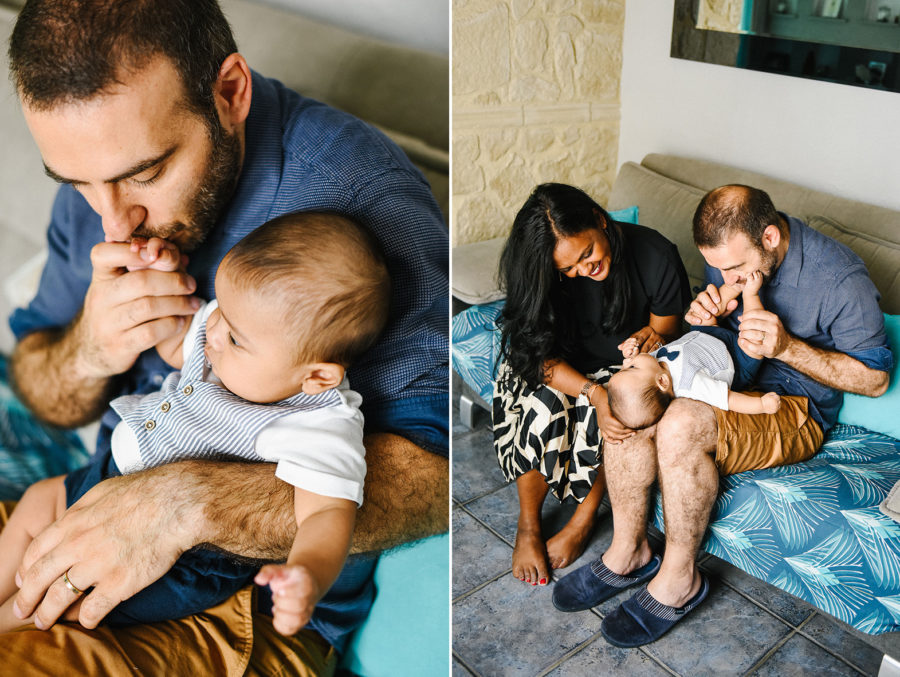 de jeunes parents sont assis avec leur enfant dans un canapé