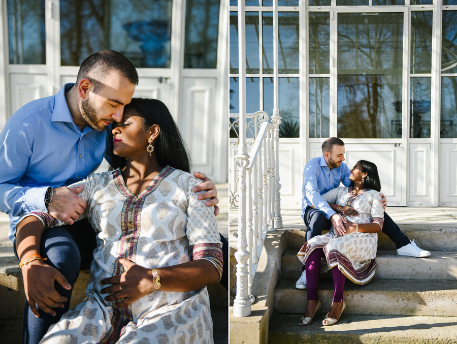 un couple de futurs parents est assis sur des escaliers dans un parc